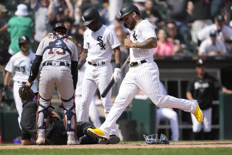 Yoan Moncada de los Medias Blancas de Chicago anota en la décima entrada frente al relevista de los Tigres de Detroit José Cisnero en el juego del sábado 3 de junio del 2023. (AP Foto/Charles Rex Arbogast)