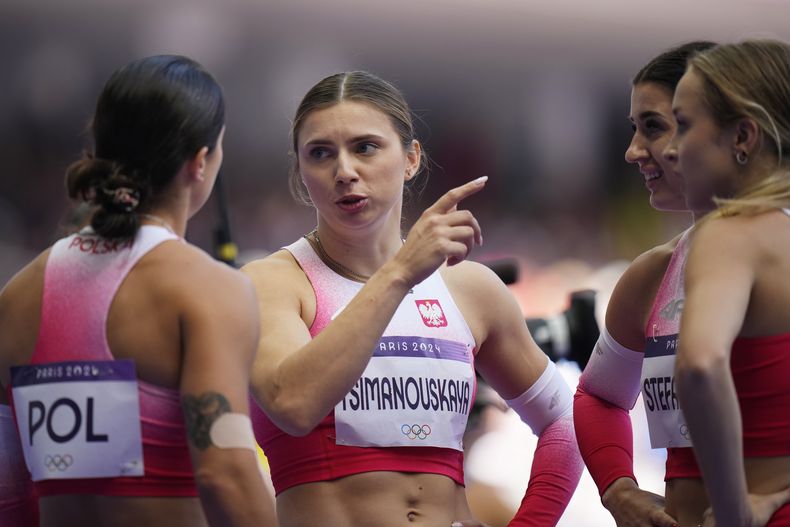 La polaca Krystsina Tsimanouskaya charla con sus compañeras del relevo femenino 4x100 en los Juegos Olímpicos de París, el jueves 8 de agosto de 2024, en Saint-Denis, Francia. (AP Foto/Petr David Josek)