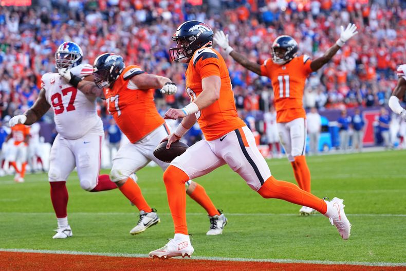 Bo Nix, al centro, quarterback de los Broncos de Denver, anota contra los Giants de Nueva York durante la segunda mitad del partido de la NFL, el domingo 19 de octubre de 2025, en Denver. (AP Foto/Jack Dempsey)