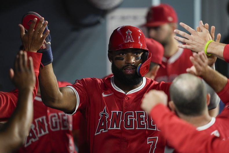 Jo Adell, de los Angelinos de Los Ángeles, festeja en la cueva luego de anotar en la décima entrada del juego del viernes 21 de junio de 2024, ante los Dodgers de Los Ángeles (AP Foto/Ashley Landis)