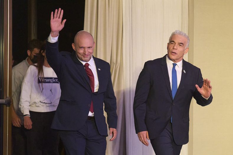 El ex primer ministro de Israel, Naftali Bennett, a la izquierda, y Yair Lapid, llegan para una conferencia de prensa para anunciar una coalición de sus partidos en las próximas elecciones, el domingo 26 de abril de 2026, en Herzliya, Israel. (AP Foto/Ariel Schalit)