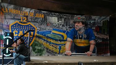 Un póster de la leyenda del fútbol Diego Maradona cuelga en las afueras del estadio La Bombonera en Buenos Aires, martes 14 de abril, 2026. (AP Foto/Natacha Pisarenko)