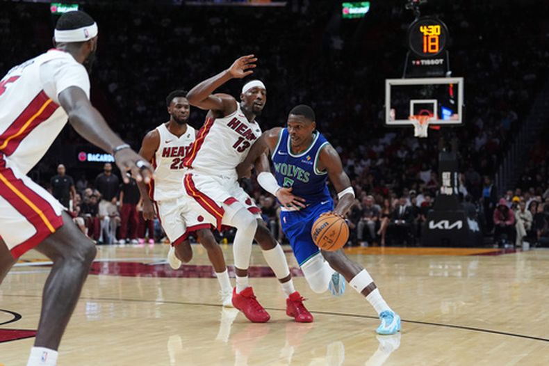 Anthony Edwards, base de los Timberwolves de Minnesota, elude a Bam Adebayo, del Heat de Miami, en el duelo del miércoles 21 de octubre de 2021 (AP Foto/Rebecca Blackwell)