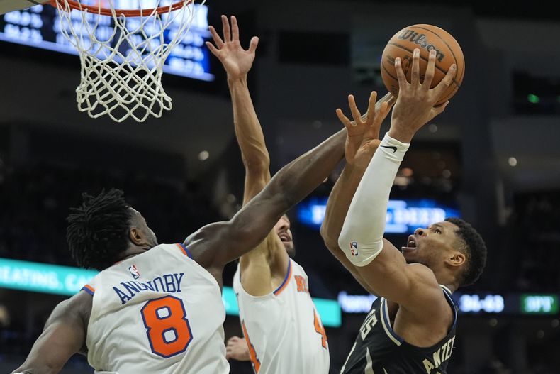 Giannis Antetokounmpo, derecha, de los Bucks de Milwaukee, intenta un tiro frente a OG Anunoby (8) y Landry Shamet, de los Knicks de Nueva York, durante la segunda mitad del juego de baloncesto de la NBA el viernes 28 de marzo de 2025, en Milwaukee. (AP Foto/Aaron Gash)