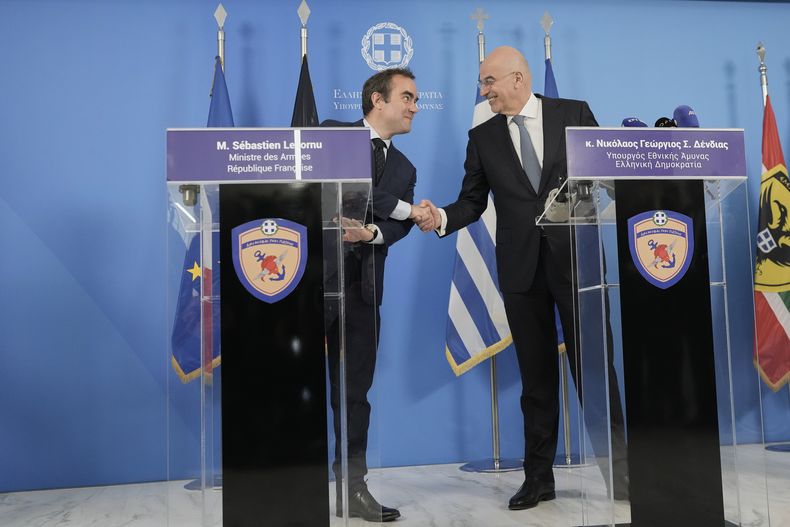 El ministro de Defensa de Grecia, Nikos Dendias, a la izquierda, y su homólogo francés, Sebastien Lecornu, se dan la mano durante una conferencia de prensa en Atenas, el lunes 14 de abril de 2025. (AP Foto/Petros Giannakouris)