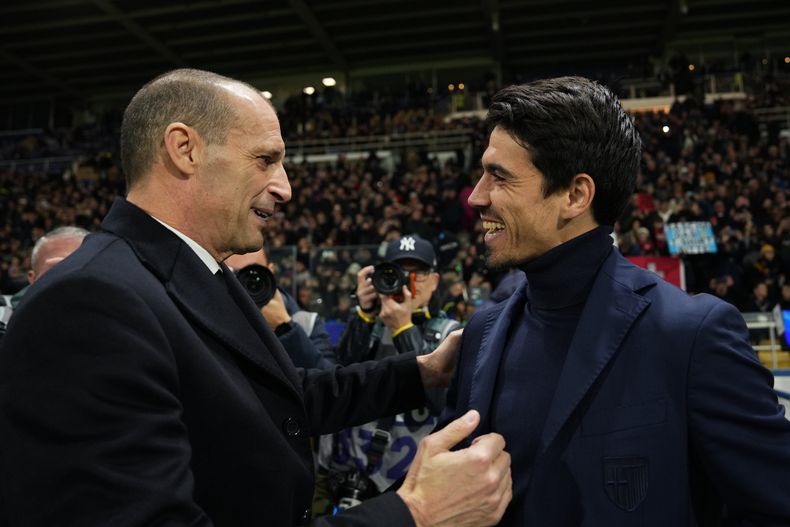 El entrenador principal del AC Milan, Massimiliano Allegri, a la izquierda, y el entrenador principal del Parma, Carlos Cuesta, se saludan antes del juego de fútbol de la Serie A entre el Parma y el Milan en Parma, Italia, el domingo 9 de noviembre de 2025. (Massimo Paolone/LaPresse vía AP)