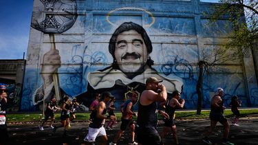 Corredores pasan por delante de un mural con la imagen de Diego Maradona durante la maratón de Buenos Aires, en Argentina, el 20 de septiembre de 2026. (AP Foto/Natacha Pisarenko)