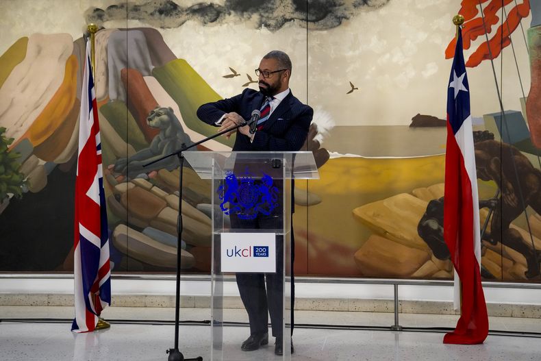 El secretario británico para Asuntos Exteriores de la Commonwealth y de Desarrollo, James Cleverly, mira su reloj mientras habla en una conferencia sobre la relación de Gran Bretaña con América Latina, en el Centro Cultural Gabriela Mistral en Santiago, Chile, el lunes 22 de mayo de 2023. (Foto AP/Esteban Félix)