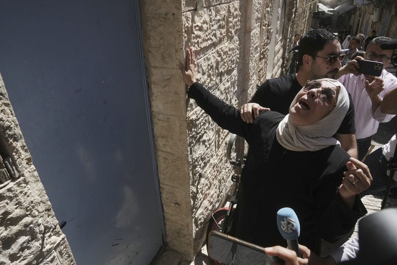 Nora Ghaith-Sub Laban toca la puerta de la casa de la que fue desahuciada su familia para dejar sitio a colonos israelíes en el casco antiguo de Jerusalén, el martes 11 de 2023. (AP Foto/Mahmoud Illean)