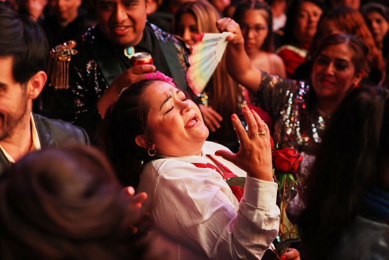 Una fan del fallecido astro del pop mexicano Juan Gabriel canta en el Zócalo, la plaza principal de la Ciudad de México, el sábado 8 de noviembre de 2025, antes de una proyección gratuita del concierto que el fallecido cantante mexicano ofreció en Bellas Artes en 1990. (AP Photo/Claudia Rosel)