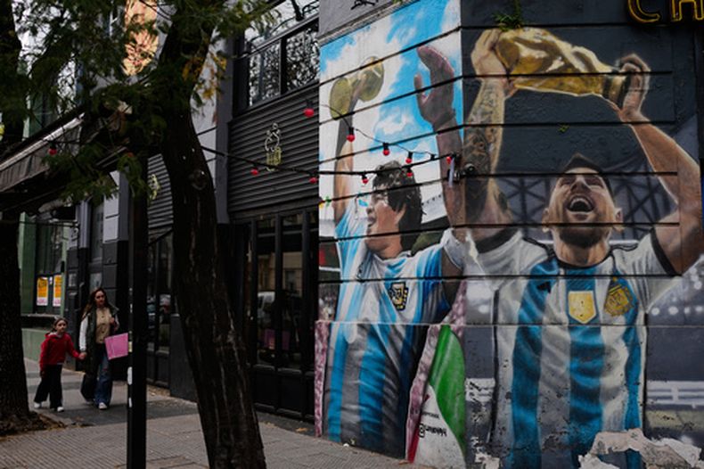 Las imágenes de los futbolistas argentinos Lionel Messi (derecha) y Diego Maradona decoran el muro de un restaurante, el lunes 31 de agosto de 2026, en Buenos Aires. (AP Foto/Natacha Pisarenko)