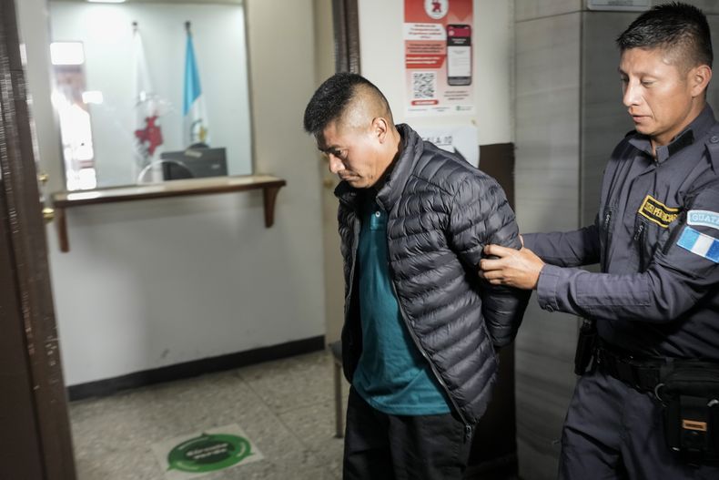 ARCHIVO - Rigoberto Román Miranda Orozco, acusado de ayudar a coordinar el intento de contrabando de migrantes de 2022 que resultó en la muerte de 53 migrantes en Texas, es escoltado por un guardia de prisión tras asistir a una audiencia judicial como parte de su proceso de extradición, en la Ciudad de Guatemala, el 5 de septiembre de 2024. (Foto AP/Moisés Castillo, Archivo)