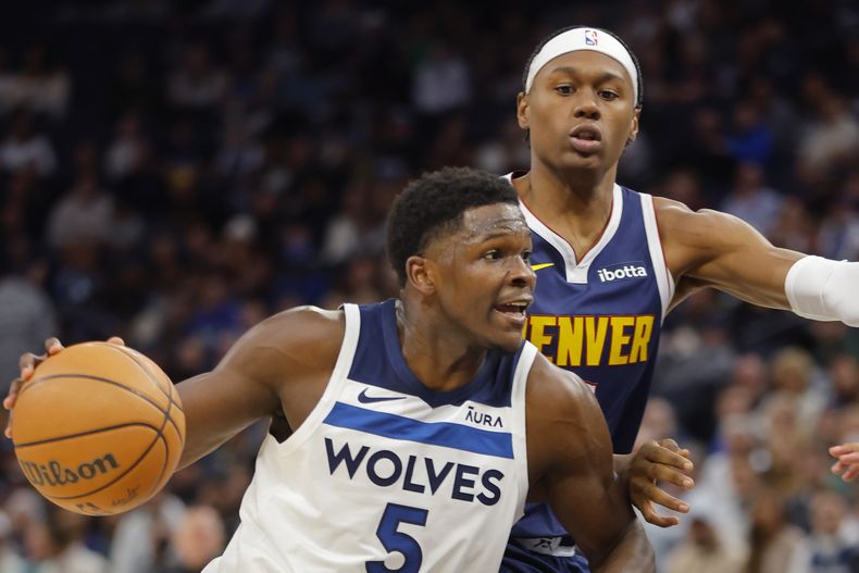 Anthony Edwards, base de los Timberwolves de Minnesota, elude a Peyton Watson, de los Nuggets de Denver, en el encuentro del miércoles 1 de noviembre de 2023 (AP Foto/Bruce Kluckhohn)