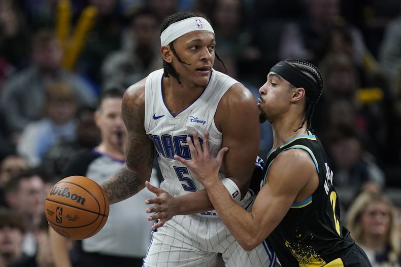Paolo Banchero, del Magic de Orlando, busca avanzar frente a Andre Nembhard, de los Pacers de Indiana, el sábado 23 de diciembre de 2023 (AP Foto/Darron Cummings)