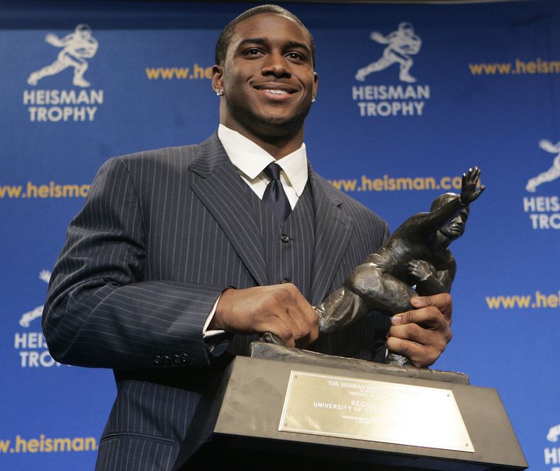ARCHIVO - Reggie Bush, de la Universidad del Sur de California, ganador del Trofeo Heisman, sonríe mientras posa para las fotogrtafías durante una conferencia de prensa en Nueva York, el 10 de diciembre de 2005. Reggie Bush fue reinstaurado como ganador del Heisman de 2005 el miércoles 24 de abril de 2024, más de una década después de que una investigación de la NCAA determinara que recibió beneficios inadmisibles durante su tiempo con los Trojans.(AP Foto/Frank Franklin II, Archivo)
