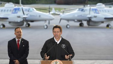 El gobernador de Florida Ron DeSantis habla en compañía de Keith Pearson, un asesor senior del Departamento de Seguridad Nacional, en conferencia de prensa en el hangar de la Oficina de Aduanas y Protección Fronteriza de Estados Unidos (CBP, por sus siglas en inglés) en la Base de la Fuerza Aérea en Homestead, Florida, el miércoles 26 de febrero de 2025. (AP Foto/Rebecca Blackwell)