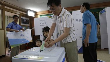 americateve | Un hombre coloca su voto en la urna junto con sus hijos en Se&uacute;l, en las elecciones locales que se celebran en Corea del Sur el mi&eacute;rcoles 4 de mayo de 2014. (Foto de AP/Lee Jin-man)