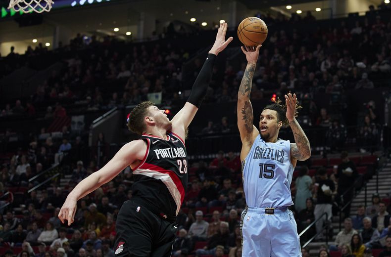 El alero de los Grizzlies de Memphis, Brandon Clarke, a la derecha, dispara sobre el pívot de los Trail Blazers de Portland, Donovan Clingan, durante la primera mitad de un partido de baloncesto de la NBA en Portland, Oregon, el miércoles 19 de marzo de 2025. (AP Foto/Craig Mitchelldyer)