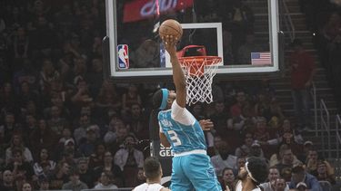 Marques Bolden de los Hornets de Charlotte salta para clavar el balón sobre Max Strus y Jarrett Allen de los Cavaliers de Cleveland en el encuentro de la NBA del domingo 14 de abril del 2024. (AP Foto/Phil Long)