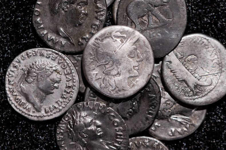 Monedas romanas, incluida la que se muestra en el centro, que data del año 148 a. C., cuando Roma aún era una República sin emperador, se exhiben en el Museo Estatal LVR de Bonn, Alemania, el martes 22 de septiembre de 2026. (Rolf Vennenbernd/dpa vía AP)