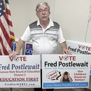 Fred Postlewait, candidato republicano a la Junta Estatal de Educación de Kansas City, Kan, muestra dos carteles disponibles para los partidarios en la sede local del Partido Republicano en el condado de Johnson, el martes 1 de octubre de 2024, en Overland Park, Kansas. (AP Foto/John Hanna)