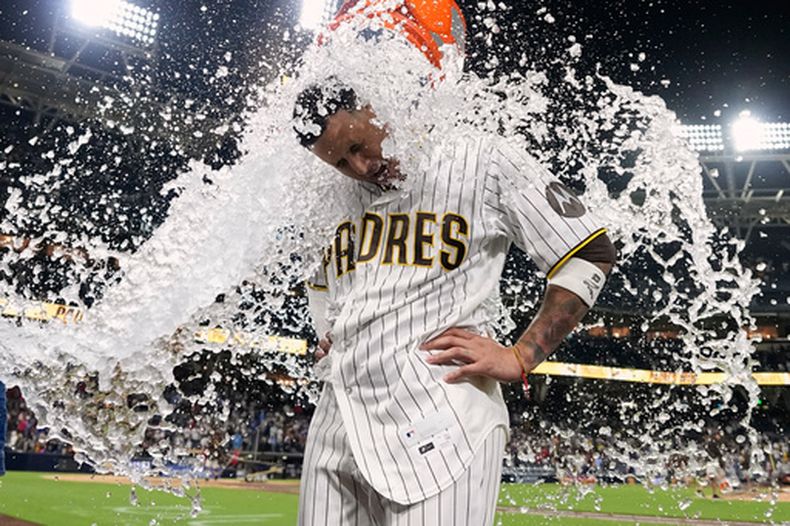 Manny Machado, de los Padres de San Diego, es bañado en celebración tras conectar un sencillo para dejar tendidos en el terreno a los Bravos de Atlanta durante la décima entrada de un partido de béisbol, el martes 23 de junio de 2026, en San Diego. (Foto AP/Gregory Bull)