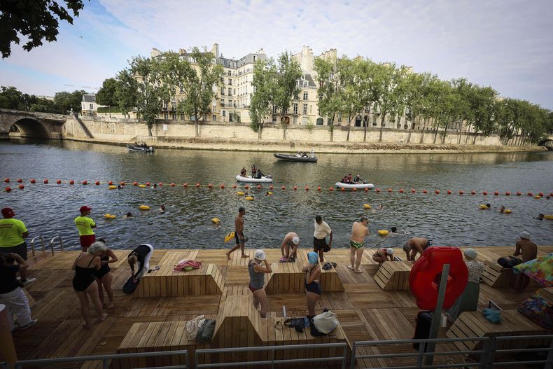 Personas nadan en la zona de baño segura de Bras Marie, en el río Sena, en París, Francia, el sábado 5 de julio de 2025, durante la inauguración de las tres piscinas del Sena, como parte del evento Paris Plages. (AP Foto/Thomas Padilla)
