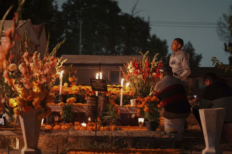 Varias familias se reúnen junto a la tumba de sus Muertos en la celebración del Día de Muertos en el cementerio de San Gregorio Atlapulco en las afueras de Ciudad de México, el viernes 1 de noviembre de 2024. (AP Foto/Moises Castillo)