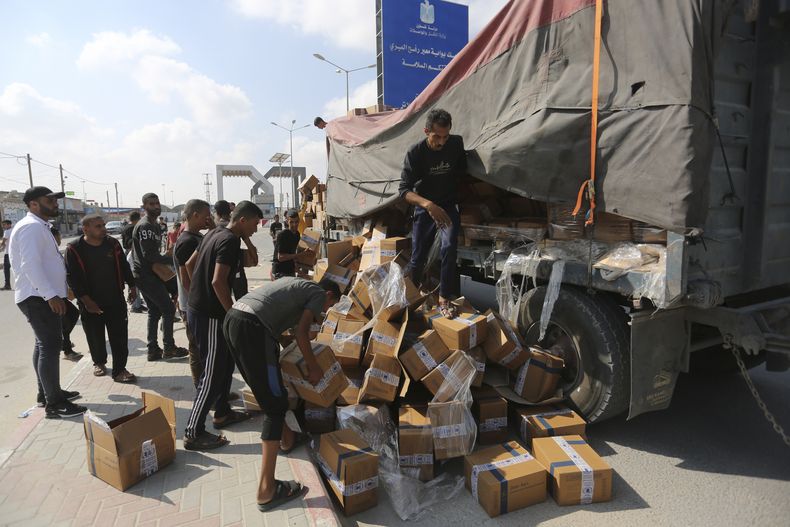Palestinos saquean un camión que transporta ayuda humanitaria el 2 de noviembre de 2023, cerca del paso fronterizo de Rafah, en la Franja de Gaza. (AP Foto/Hatem Ali)