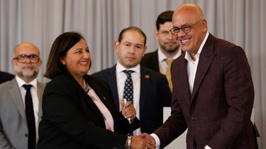 Dinorah Figuera, representante de la oposición venezolana, izquierda, y el presidente de la Asamblea Nacional, Jorge Rodríguez, se estrechan la mano tras firmar acuerdos al finalizar la segunda ronda de conversaciones políticas, el viernes 25 de septiembre de 2026, en Caracas, Venezuela. (AP Foto/Pedro Mattey)