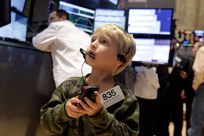 Jordan Kessler, el hijo de 5 a&ntilde;os del corredor Glenn Kessler, usa el tel&eacute;fono celular y la identificaci&oacute;n de su padre mientras visita el piso de remates de la Bolsa de Valores de Nueva York, el viernes 28 de noviembre de 2014. (Foto A