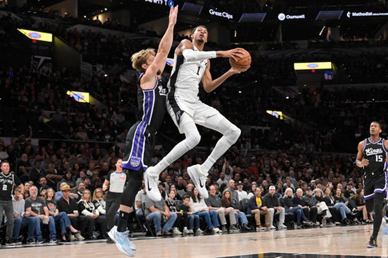 El pívot de los Spurs de San Antonio, Victor Wembanyama (1), avanza hacia la canasta ante la defensa del pívot de los Kings de Sacramento, Domantas Sabonis, durante la primera mitad de un partido de básquetbol de la NBA, el martes 27 de octubre de 2026, en San Antonio. (Foto AP/Darren Abate)