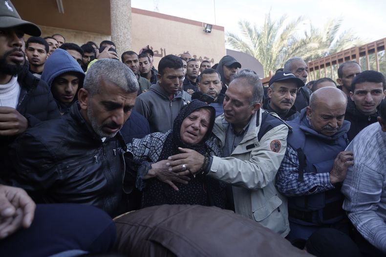 Familiares del cámara de Al Jazeera Samer Abu Daqqa, que murió por un ataque aéreo israelí, lloran su muerte durante su funeral en Jan Yunis, en el sur de la Franja de Gaza, el 16 de diciembre de 2023. (AP Foto/Mohammed Dahman)