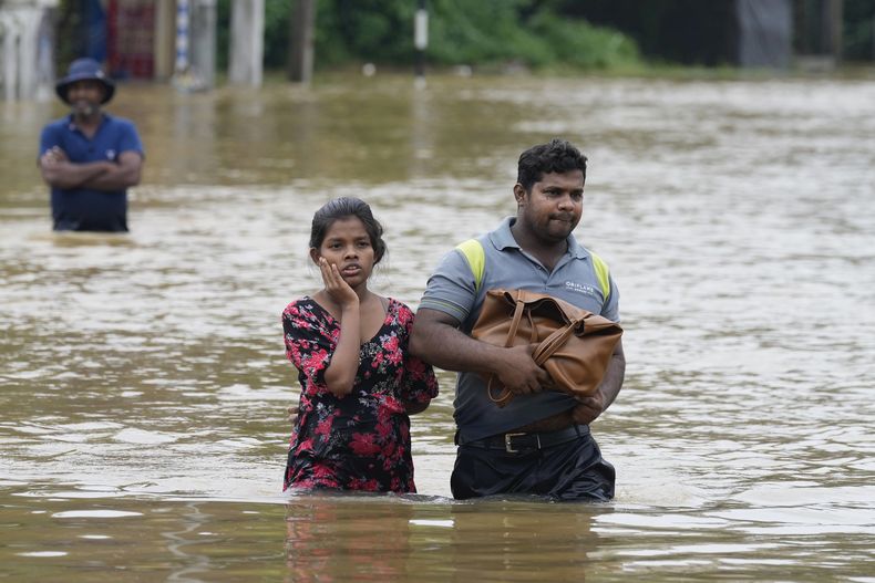 Gente vadea zonas inundadas en Kelaniya, un suburbio de Colombo, Sri Lanka, el lunes 3 de junio de 2024. Sri Lanka cerró las escuelas el lunes después de que fuertes lluvias provocaran inundaciones y aludes de lodo en gran parte de la nación insular, donde al menos 10 perspnas murieron y seis estaban desaparecidas, según las autoridades. (AP Foto/Eranga Jayawardena)