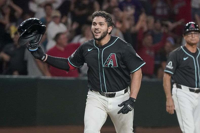 Adrián Del Castillo, de los Diamondbacks de Arizona, celebra su primer jonrón en Grandes Ligas, con el que dejaron tendidos a los Filis de Filadelfia en la novena entrada del juego de béisbol del viernes 9 de agosto de 2024, en Phoenix. (AP Foto/Darryl Webb)
