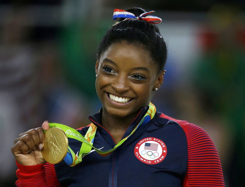 ARCHIVO - La gimnasta estadounidense Simone Biles muestra su medalla de oro tras ganar la competencia de suelo en los Juegos Olímpicos de Río de Janeiro, el 16 de agosto de 2016. (AP Foto/Rebecca Blackwell)