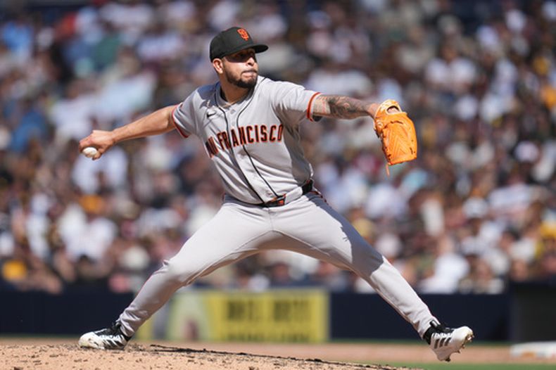 El lanzador de los Gigantes de San Francisco, José Buttó, lanza contra un bateador de los Padres de San Diego durante la octava entrada de un partido de béisbol el miércoles 1 de abril de 2026, en San Diego. (AP Foto/Gregory Bull)
