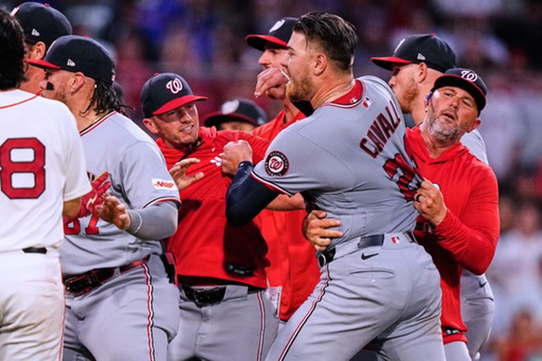 Cade Cavalli de los Nacionales de Washington es contenido por sus compañeros después de que comenzara una pelea en el encuentro ante los Medias Rojas de Boston el martes 30 de junio del 2026. (AP Foto/Charles Krupa)