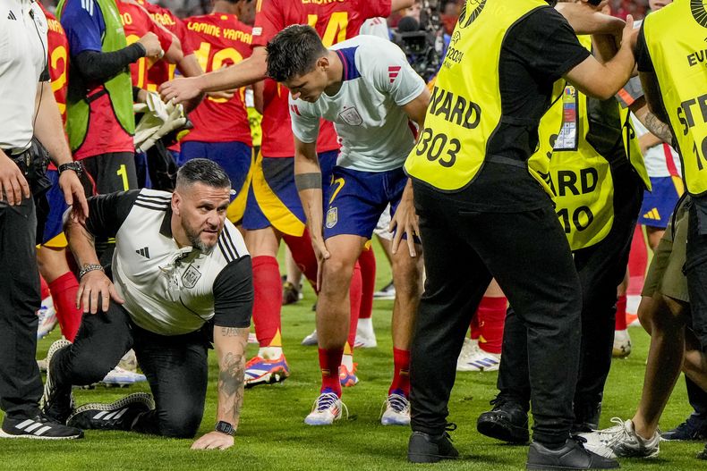 Álvaro Morata, de la selección española, se sujeta una pierna tras ser golpeado accidentalmente por un guardia de seguridad tras la semifinal de la Euro ante Francia, el martes 9 de julio de 2024 (AP Photo/Hassan Ammar)