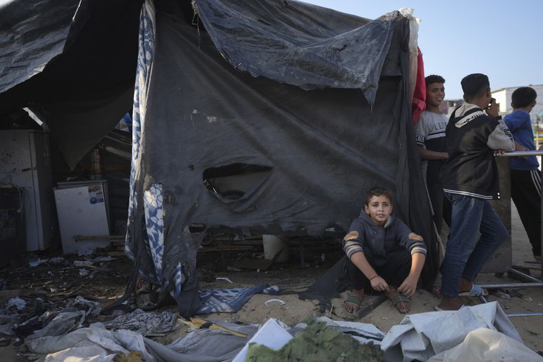 Varios Palestinos se reúnen en el sitio de un ataque israelí en el patio del Hospital Al-Aqsa, donde viven personas desplazadas en carpas, en Deir al-Balah, Franja de Gaza, el sábado 9 de noviembre de 2024. (AP Foto/Abdel Kareem Hana)