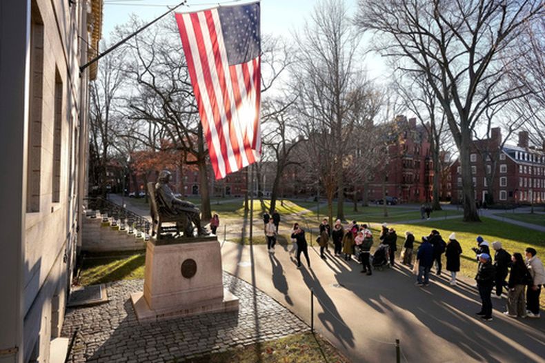 Unas personas toman fotos a la estatua de John Harvard, en la Universidad de Harvard, el 2 de enero de 2024, en Cambridge, Massachusetts. (AP Foto/Steven Senne, Archivo)