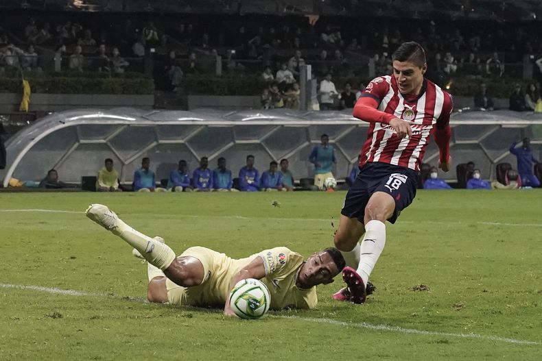 Ronaldo Cisneros, del Guadalajara, anota el primer gol de su equipo al dejar atrás a Sebastián Cáceres, del América, en el partido de vuelta de las semifinales del torneo mexicano, el domingo 21 de mayo de 2023, en la Ciudad de México. (AP Foto/Eduardo Verdugo)
