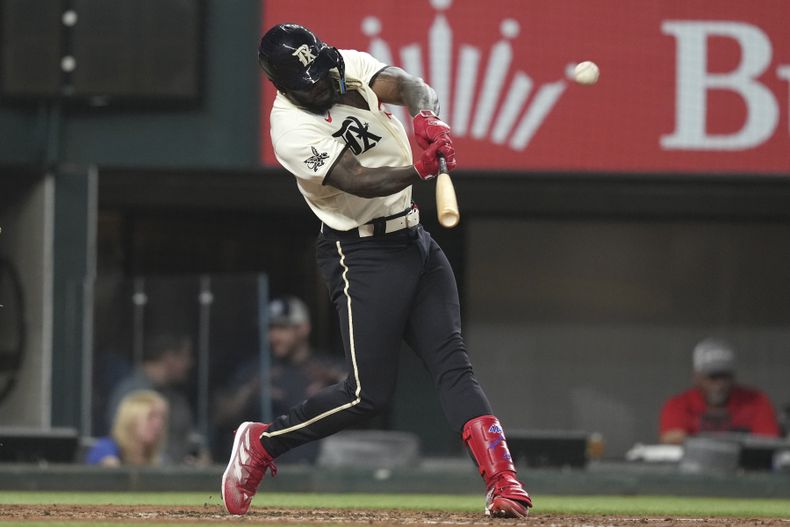 Adolis García, de los Rangers de Texas, batea cuadrangular de dos carreras durante la cuarta entrada del juego de béisbol en contra de los Rickies de Colorado, en Arlington, Texas, el viernes 19 de mayo de 2023. Nathaniel Lowe también anotó en la jugada. (AP Photo/LM Otero)