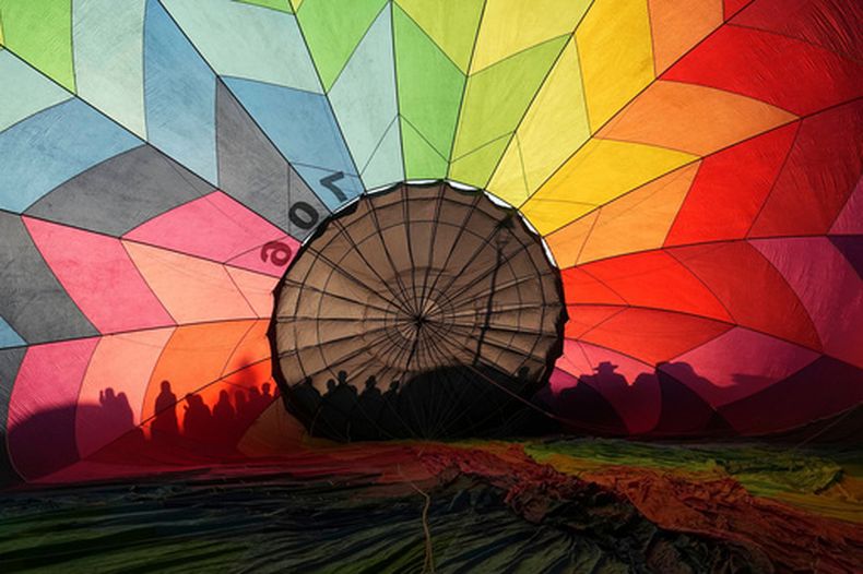 Las sombras de varias personas se proyectan sobre un globo aerostático durante la quinta edición del Festival Internacional de Globos Aerostáticos Mitad del Mundo» en Quito, Ecuador, el viernes 21 de agosto de 2026.(AP Foto/Dolores Ochoa)