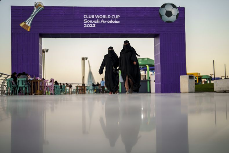 Dos mujeres caminan frente a la fan zone del Mundial de Clubes en el malecón de Yeda, Arabia Saudí, el miércoles 13 de diciembre de 2023. (AP Foto/Manu Fernández)