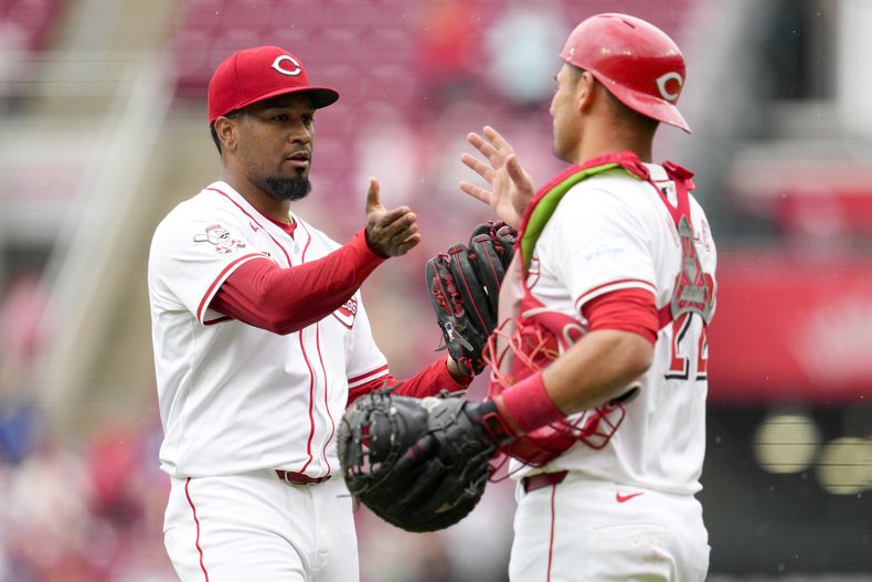 Alexis Díaz (izquierda) y Luke Maile de los Rojos de Cincinnati celebran la victoria ante los Dodgers de Los Ángeles, el domingo 26 de mayo de 2024. (AP Foto/Jeff Dean)