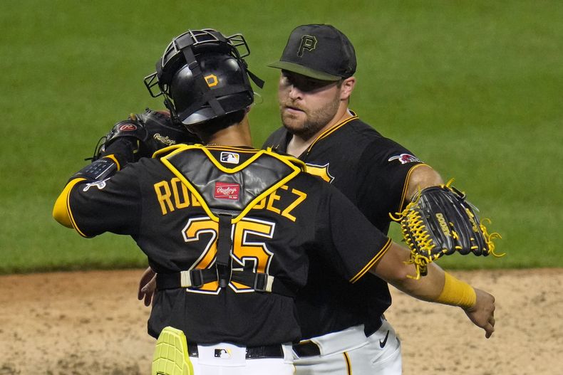 El relevista de los Piratas de Pittsburgh David Bednar celebra con su compañero de equipo el receptor Endy Rodríguez luego del último out de juego ante los Bravos de Atllanta, en Pittsburgh. Lunes 7 de agosto de 2023. (AP Foto/Gene J. Puskar)