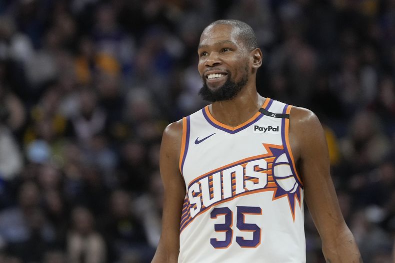 El alero de los Suns de Phoenix Kevin Durant sonríe durante el encuentro ante los Warriors de Golden State el viernes 31 de enero del 2025. (AP Foto/Jeff Chiu)