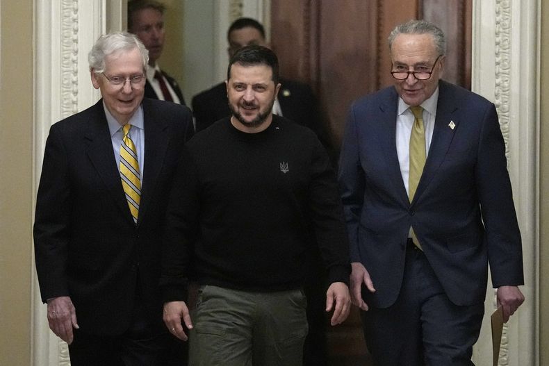 El presidente ucraniano Volodymyr Zelenskyy, centro, entra al Capitolio flanqueado por el líder de la minoría Mitch McConnell, izquierda, y el líder de la mayoría Chuck Schumer, Washington, martes 12 de diciembre de 2023. (AP Foto/Susan Walsh)