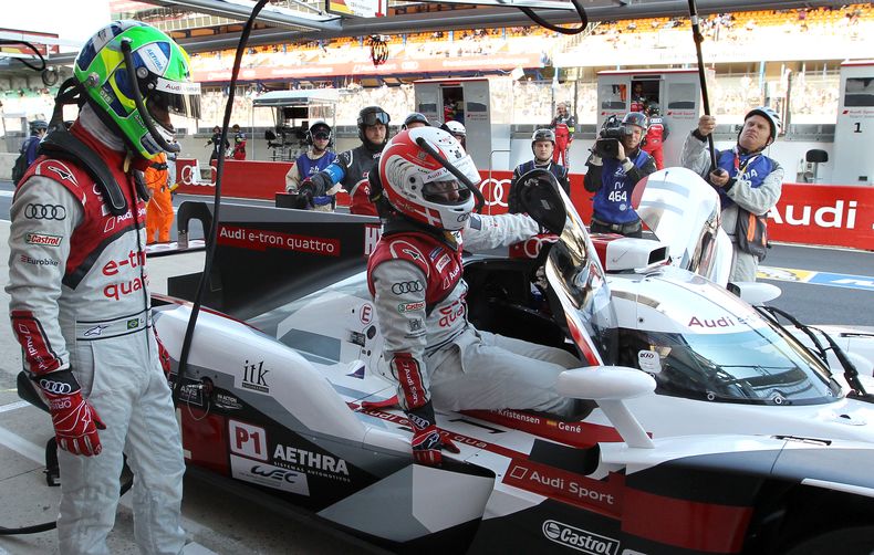 El piloto Tom Kristensen baja del Audi R18 mientras lo observa su compa&ntilde;ero Lucas Di Grassi, antes de empezar las 24 Horas de Le Mans el 14 de junio del 2014. (AP Foto/Bob Edme))